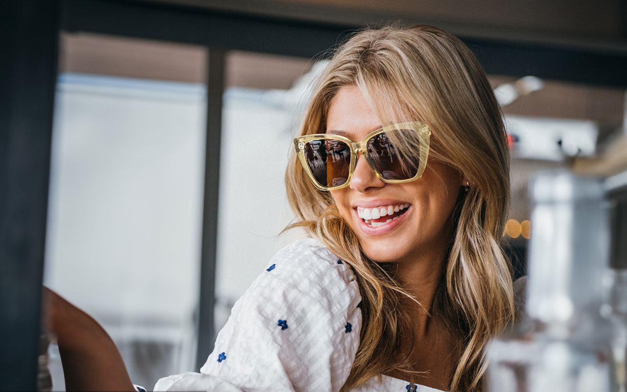Woman smiling in ivory oversized polarized sunglasses – perfect Mother’s Day gift idea for stylish moms, featuring Kaenon eyewear.